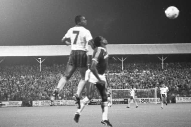 North End midfielder Oshor Williams challenges in the air against West Ham, with a busy Kop in the background