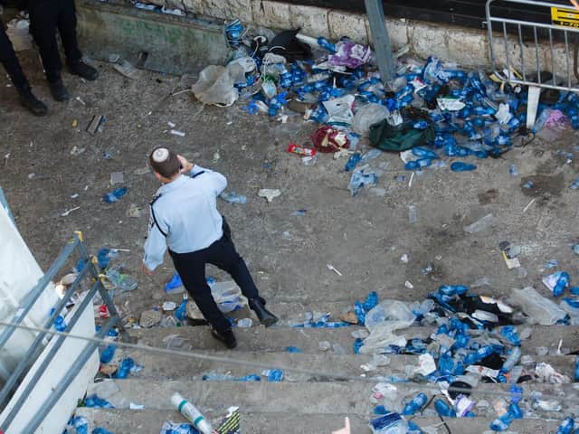 A police officer walks at the scene where dozens were killed in a crush at a religious festival in Mount Meron on April 30, 2021 in Meron, Israel. At least 44 people were crushed to death and over 150 more injured in a stampede, as tens of thousands of ultra-Orthodox Jews gathered to celebrate the Lag B'omer event, late Thursday. (Photo by Amir Levy/Getty Images)