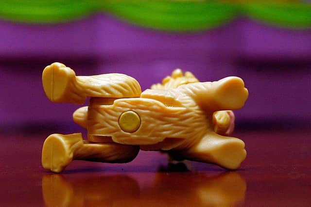 A 1/8-inch magnet is shown attached to the underside of a dog from the Polly Pocket toy series