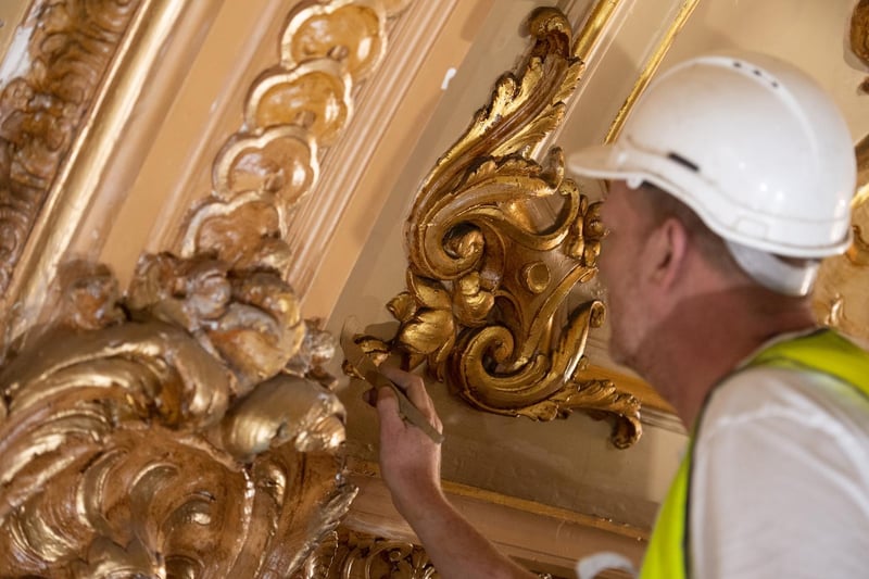A craftsmen gives the ballroom ceiling a fresh look