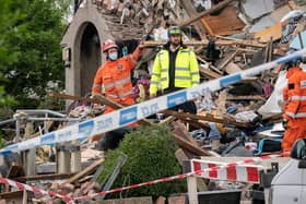 Emergency workers at the scene of a suspected gas explosion, in which a young child was killed and two people were seriously injured