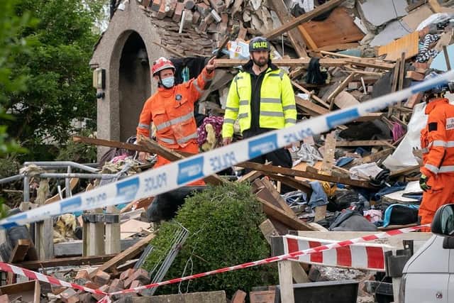 Emergency workers at the scene of a suspected gas explosion, in which a young child was killed and two people were seriously injured