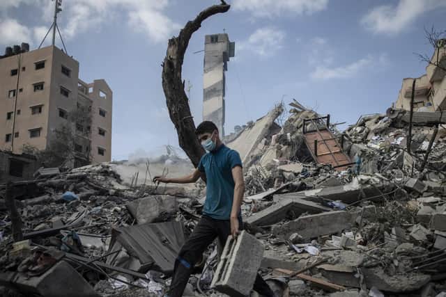A Palestinian citizen surveys the rubble of a building in the aftermath of an Israeli air force strike