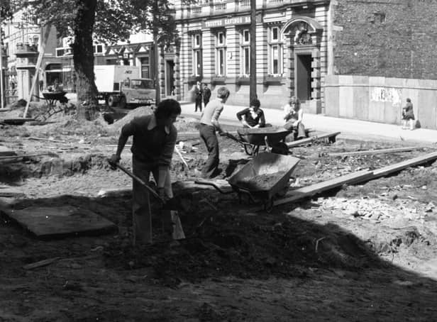 Men start work at Preston Parish Church, digging up ancient tombstones during landscaping