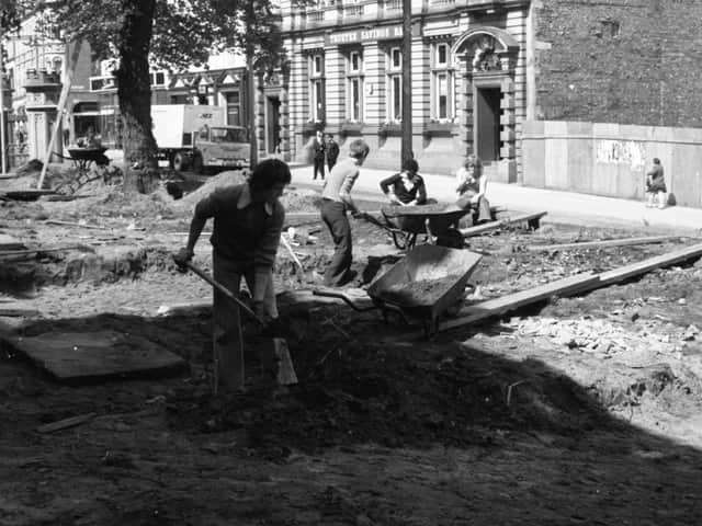 Men start work at Preston Parish Church, digging up ancient tombstones during landscaping