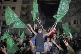 Palestinians, waving Hamas flags, celebrate the ceasefire on the streets of Gaza City.