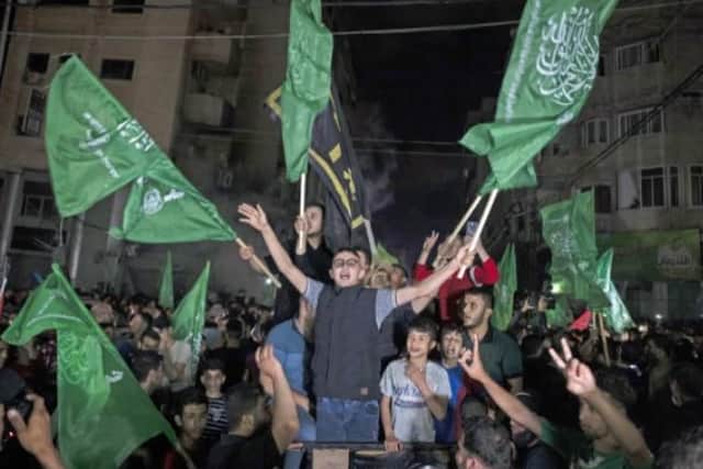 Palestinians, waving Hamas flags, celebrate the ceasefire on the streets of Gaza City.