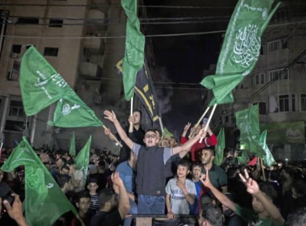 Palestinians, waving Hamas flags, celebrate the ceasefire on the streets of Gaza City.