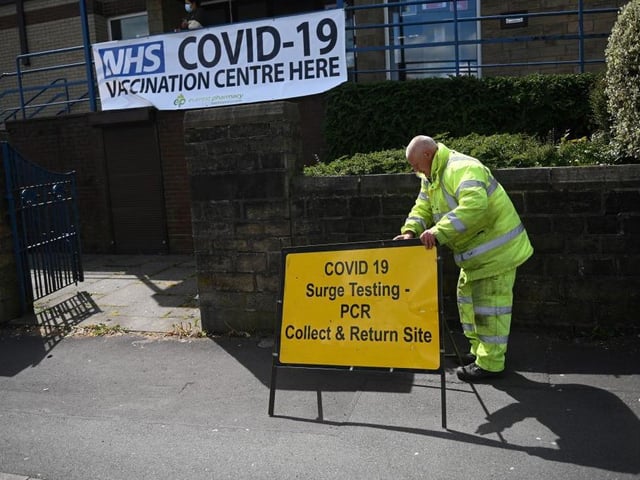 A worker sets outs a sign for a Covid-19 PCR Surge testing site, and vaccination centre, at the United Reformed Church in Blackburn