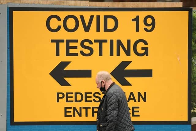 A pedestrian walks past a sign directing members of the public to a Covid-19 testing centre in Bolton,