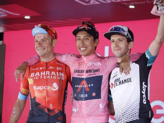 Colombia's Egan Bernal is flanked by runner-up Italy's Damiano Caruso, and Third placed Britain's Simon Yates, right, as he celebrates on podium after completing the final stage to win the Giro d'Italia cycling race, in Milan, Italy.