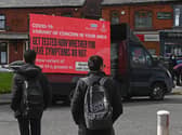 Information advising people to get tested due to the prevalence of a coronavirus covid-19 variant is displayed on a screen attached to a vehicle on the streets of Blackburn.