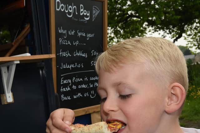 Delicious! Freddie Ward, 8, tries the pizza he designed for Dough Boy.