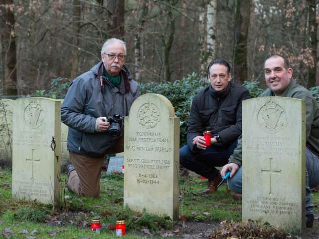Members of the Overloon War Chronicles group by the side of gravestones in the Overloon Cemetery. Picture by albert-hendriks.