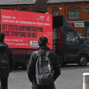 Information advising people to get tested due to the prevalence of a coronavirus covid-19 variant is displayed on a screen attached to a vehicle on the streets of Blackburn.