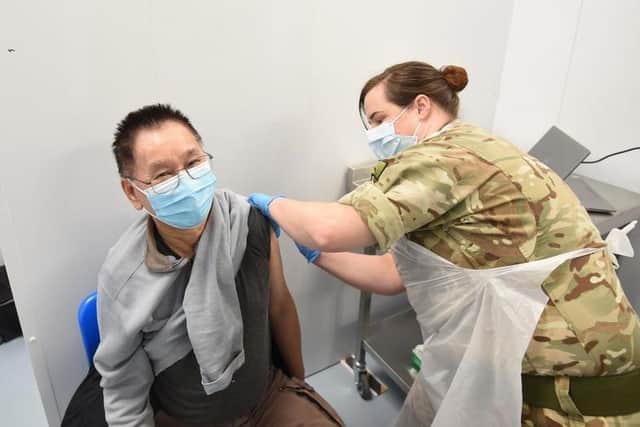 Yam Yau Wong is vaccinated by Sgt Jess Worth at the vaccine clinic in St John's Shopping Centre, Preston