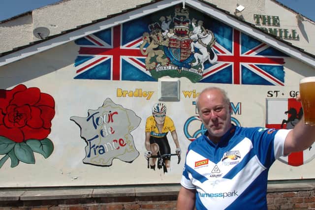 Barry Woods raises a glass to Tour de France winner Bradley Wiggins after painting this mural on the wall of the old Eccleston pub, The Windmill, in 2012