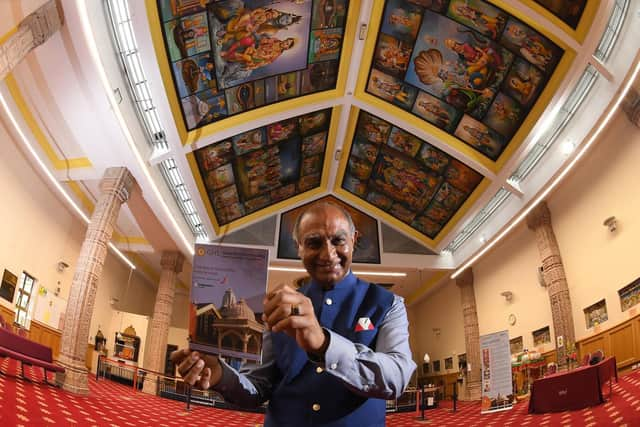 Ishwer Tailor  pictured inside the temple with the new guidebook  Photo: Neil Cross