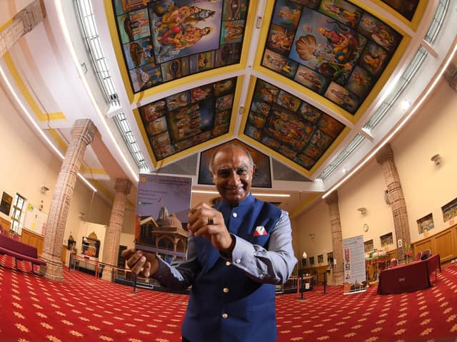 Ishwer Tailor  pictured inside the temple with the new guidebook  Photo: Neil Cross