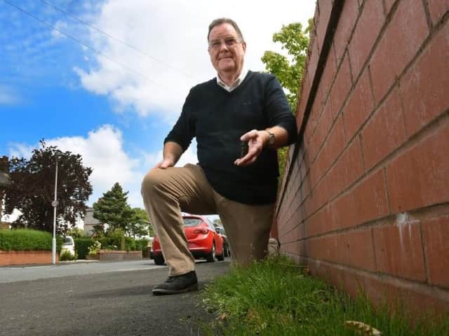 Councillor David Howarth with the weeds that have grown through the resurfacing