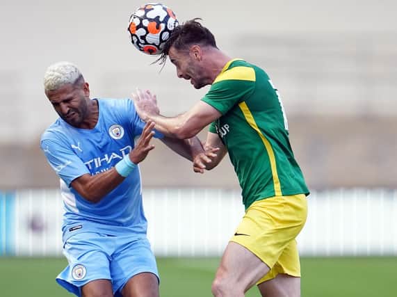 Andrew Hughes rises ahead of Riyad Mahrez.