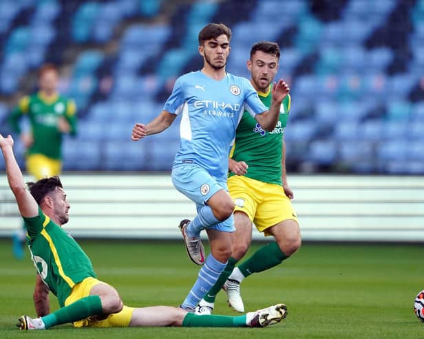PNE defender Andrew Hughes slides in to tackle Manchester City's Iker Pozo as Ben Whiteman closes in
