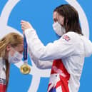 Kathleen Dawson of Team GB (right) places the gold medal around Anna Hopkin’s neck (Getty Images)