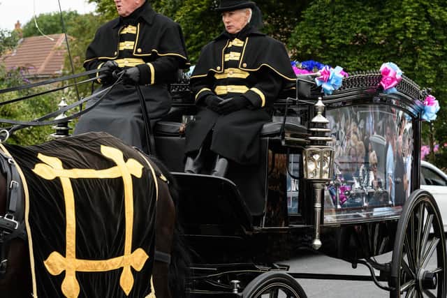 A horse-drawn carriage takes Frank Varey on his final journey.