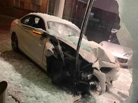 Pictures from the scene show the wrecked BMW under ablizzard of shattered glass and just inches away from the display of luxury cars, with some price-tagged atmore than 100,000