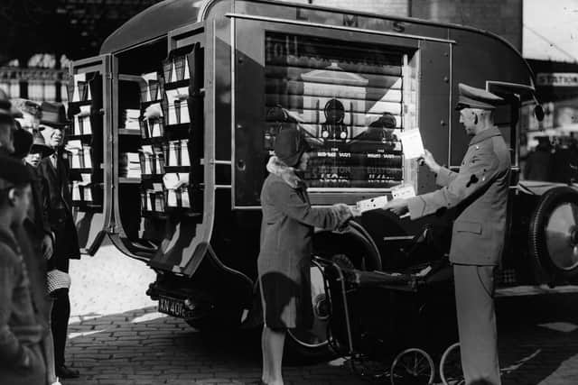 A woman receives information leaflets about holidays from a publicity van belonging to the London Midland and Scottish Railway Company, in Blackpool