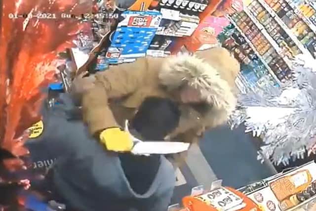 This is the moment a shopkeeper fought off a knife-wielding robber with a wine bottle in Blackburn. (Credit: Lancashire Police)