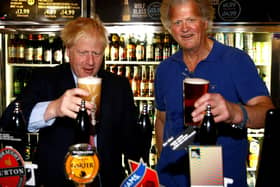 Boris Johnson (L) poses with a pint of beer as he talks with JD Wetherspoon chairman Tim Martin during his visit to their Metropolitan Bar in London, on July 10, 2019.