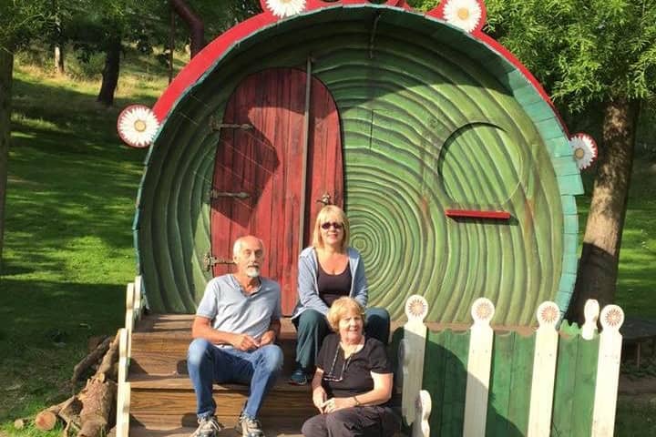 Sue Mantle (front) with her niece Lisa and her husband Gerry with the house in The Hobbit, The Dukes promenade play in Williamson Park, Lancaster in 2016. The picture was taken by Sue's great nephew Alfie.