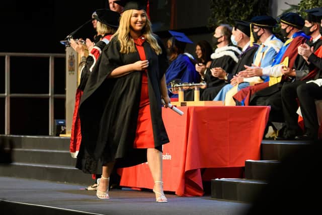 One proud graduate takes to the stage with her certificate.