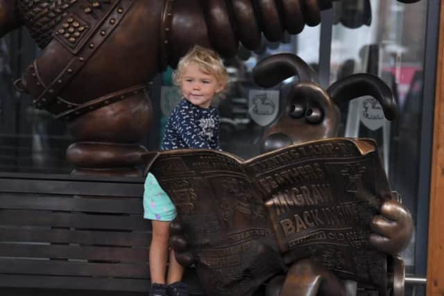 A young Wallace and Gromit fan gets a close look at the bronze.