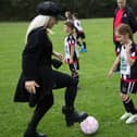 Freestyle footballer Liv Cooke puts a Lostock Hall JFC player through her paces