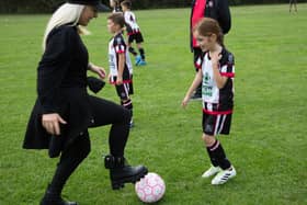 Freestyle footballer Liv Cooke puts a Lostock Hall JFC player through her paces