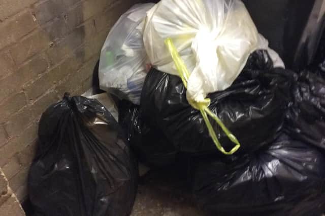 Rubbish bags, photographed by Mell, piled up in the indoor bin room at Lostock Court.