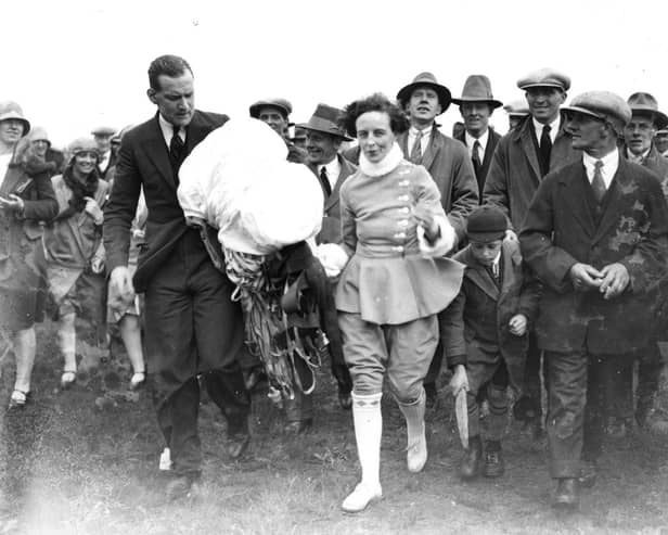 A crowd following Miss June after she had completed a parachute jump from an air balloon at Blackpool Air Pageant.  (Photo by Central Press/Getty Images)