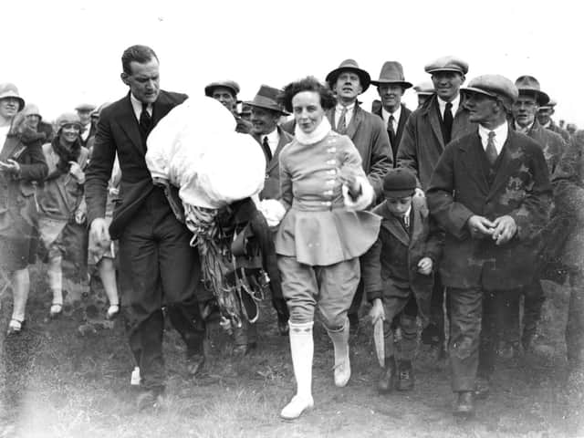 A crowd following Miss June after she had completed a parachute jump from an air balloon at Blackpool Air Pageant.  (Photo by Central Press/Getty Images)