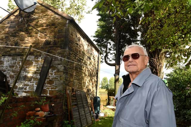 Roger Galley in the garden of his home on Chorley Road - he has suggested the 5G mast would be better sited on the playing field perimeter outside his boundary - as it would be screened by the conifers in his garden and be less obtrusive.  Photo: Neil Cross