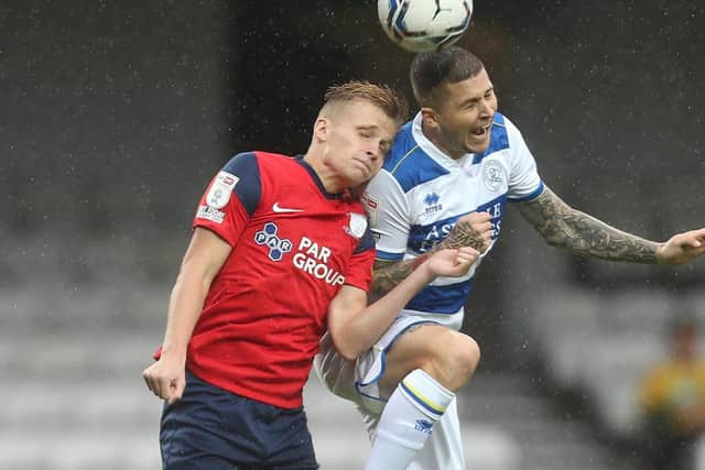 Preston North End midfielder Ali McCann challenges in the air with QPR's Lyndon Dykes