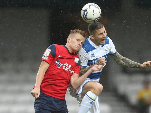 Preston North End midfielder Ali McCann challenges in the air with QPR's Lyndon Dykes