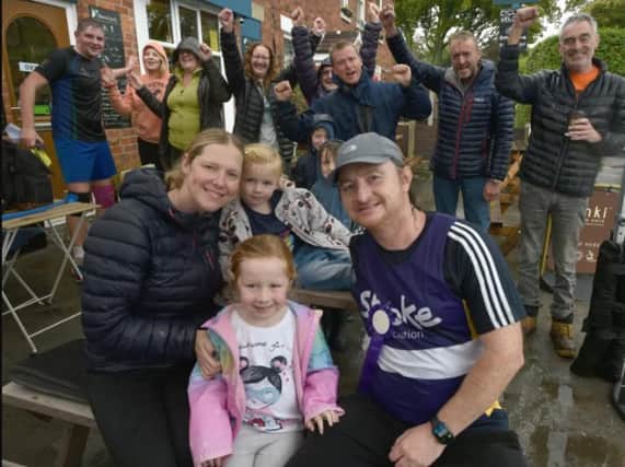 Michael with wife Amanda and children Alice and Rose celebrate with supporters on the finish line at the Lemon Tree cafe/bar in Longton.