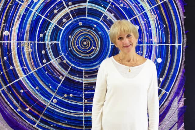 Textile artist, Jacqui Parkinson, with one of the huge Threads Through Creation panels she has produced.