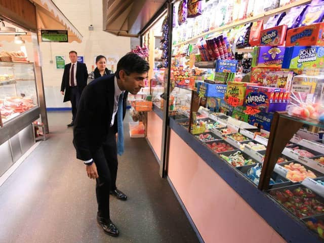 Britain's Chancellor of the Exchequer Rishi Sunak stops at a sweet shop at the Bury Market (Photo by Lindsey Parnaby-WPA Pool/Getty Images)