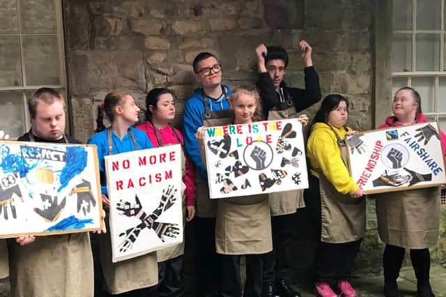 Pupils of Loyne Specialist School with placards they created during a Facing The Past art workshop