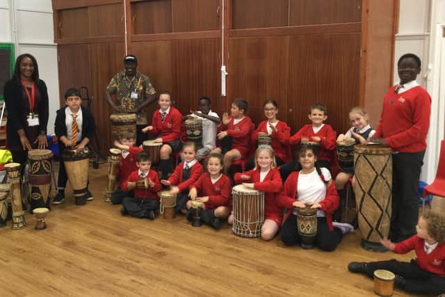 The children learnt about the history of African drumming. From left to right, at the back is Miss Judith Ward, Anas, Phil Kaila, Keeley, Alegria, Keelan, Zahra, Reece, Freya, and Merdi, whilst at the front is Luca, James, Emily, Gypsy-May, Nancy, Amna and Leighton.