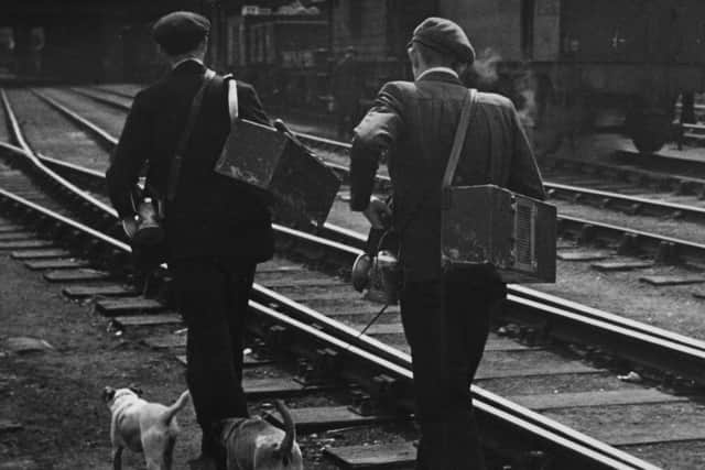 Railway rat catchers walk along a railway track