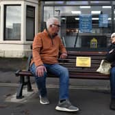 Ron Kempshall and Kath Lewis sat on the new "Happy to Chat" bench that has been installed in memory of Coun Christine Melia in Station Rd, Bamber Bridge